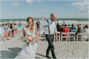Boho beach wedding bride and groom with floral accents