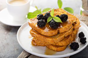Pumpkin french toast with berries and maple syrup for breakfast